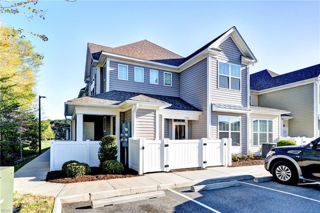 1206 Tides Edge Ct, Hampton, VA 23666 - townhome / multi-family property with a gate, uncovered parking, a fenced front yard, central AC unit, and roof with shingles