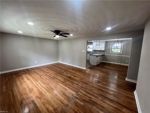 6217 Apple St, Suffolk, VA 23435 - unfurnished living room featuring dark wood-style flooring, baseboards, ceiling fan, a chandelier, and recessed lighting