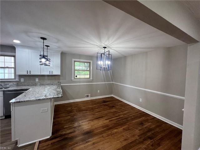 6217 Apple St, Suffolk, VA 23435 - kitchen with a chandelier, white cabinetry, dark wood finished floors, light stone counters, and stainless steel dishwasher