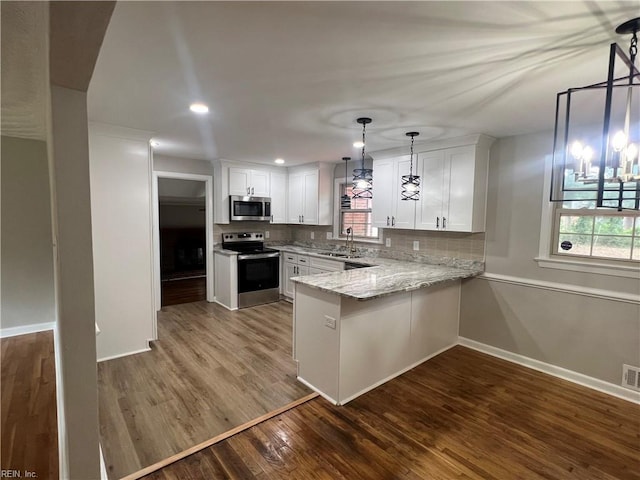 6217 Apple St, Suffolk, VA 23435 - kitchen with stainless steel appliances, a sink, dark wood-style floors, a peninsula, and white cabinets