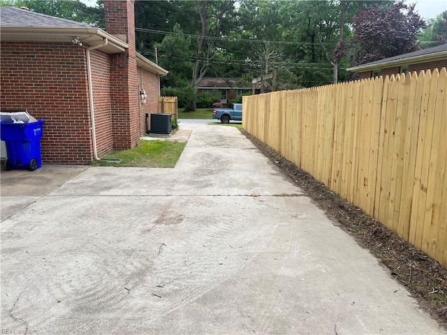 6217 Apple St, Suffolk, VA 23435 - view of side of property with brick siding, a chimney, central AC unit, and concrete driveway