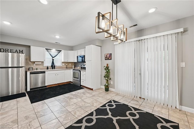2405 Minnesota Ave, Norfolk, VA 23513 - kitchen with appliances with stainless steel finishes, decorative backsplash, white cabinetry, light countertops, and pendant lighting