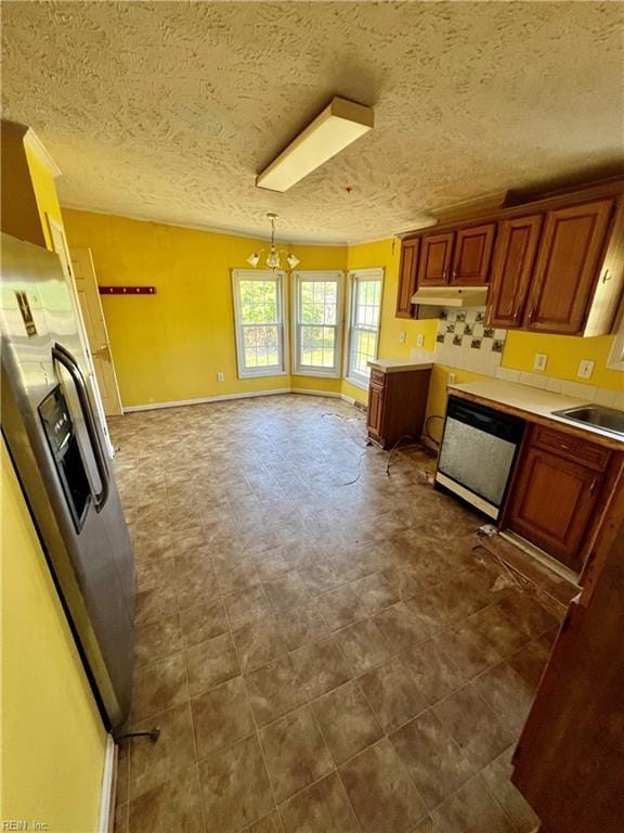 15310 Loco School Rd, Stony Creek, VA 23882 - kitchen featuring dishwashing machine, under cabinet range hood, a sink, a textured ceiling, and a chandelier