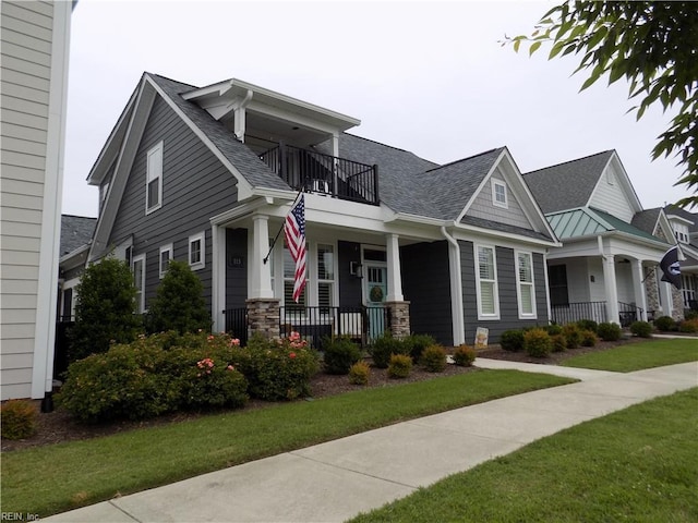 115 Creek Ln, Suffolk, VA 23435 - view of front of property with a porch, a balcony, a shingled roof, a front yard, and stone siding