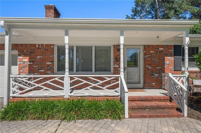 725 Lord Nelson Dr, Virginia Beach, VA 23464 - doorway to property featuring brick siding, a porch, and a chimney