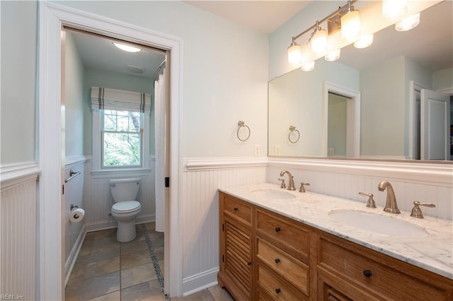 440 Goodspeed Rd, Virginia Beach, VA 23451 - bathroom featuring a wainscoted wall, double vanity, and toilet