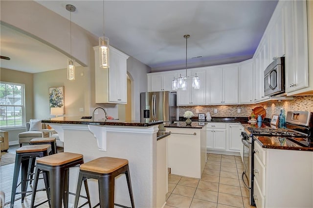 501 Beagle Gap Ct, Chesapeake, VA 23320 - kitchen with appliances with stainless steel finishes, arched walkways, decorative backsplash, and a peninsula