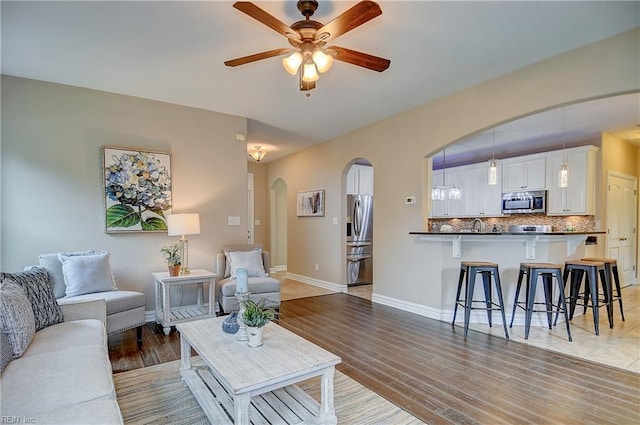 501 Beagle Gap Ct, Chesapeake, VA 23320 - living room featuring ceiling fan, arched walkways, baseboards, and light wood finished floors