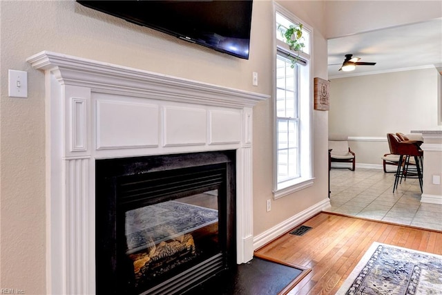 604 Schooner Blvd, Williamsburg, VA 23185 - detailed view of a glass covered fireplace, wood finished floors, baseboards, crown molding, and ceiling fan