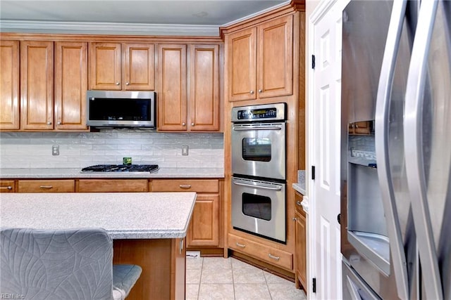 604 Schooner Blvd, Williamsburg, VA 23185 - kitchen with appliances with stainless steel finishes, brown cabinetry, backsplash, light countertops, and ornamental molding