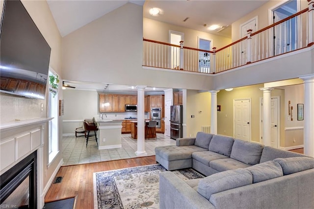 604 Schooner Blvd, Williamsburg, VA 23185 - living area featuring decorative columns, high vaulted ceiling, light wood-style floors, baseboards, and a fireplace