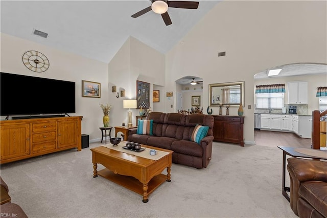 2612 Einstein Dr, Virginia Beach, VA 23456 - living room featuring a ceiling fan, light colored carpet, arched walkways, high vaulted ceiling, and baseboards