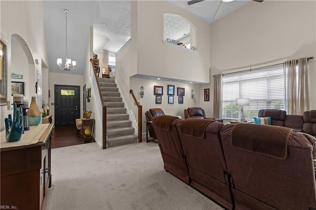 2612 Einstein Dr, Virginia Beach, VA 23456 - living room featuring high vaulted ceiling, plenty of natural light, light colored carpet, a chandelier, and stairway