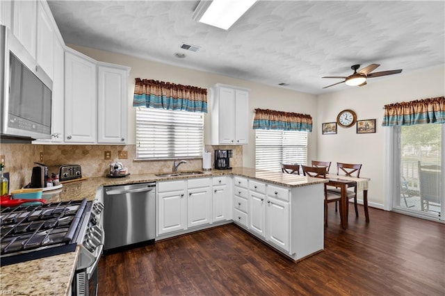 2612 Einstein Dr, Virginia Beach, VA 23456 - kitchen with appliances with stainless steel finishes, a sink, a peninsula, dark wood finished floors, and a textured ceiling