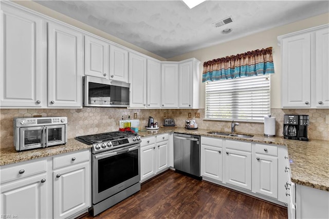 2612 Einstein Dr, Virginia Beach, VA 23456 - kitchen featuring appliances with stainless steel finishes, a sink, white cabinets, and dark wood-type flooring