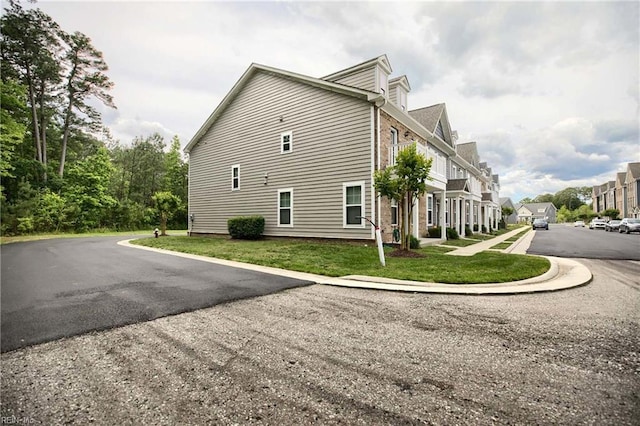101 Daybeacon St, Yorktown, VA 23692 - view of side of home with a lawn, a residential view, and asphalt driveway