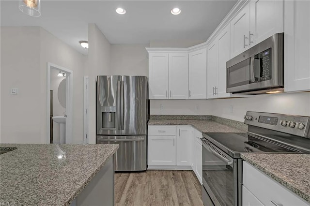 101 Daybeacon St, Yorktown, VA 23692 - kitchen featuring stainless steel appliances, light wood-style floors, white cabinetry, light stone counters, and recessed lighting