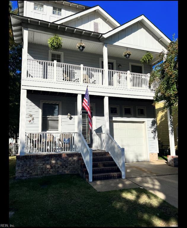 2424 Tranquility Ln, Virginia Beach, VA 23455 - view of front facade featuring a balcony, an attached garage, a porch, driveway, and board and batten siding