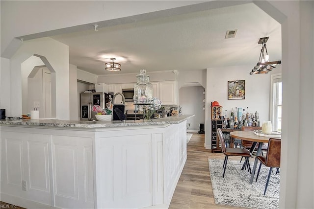 3145 Crestwood Ln, Virginia Beach, VA 23453 - kitchen featuring stainless steel appliances, light wood-style flooring, white cabinets, light stone countertops, and a chandelier