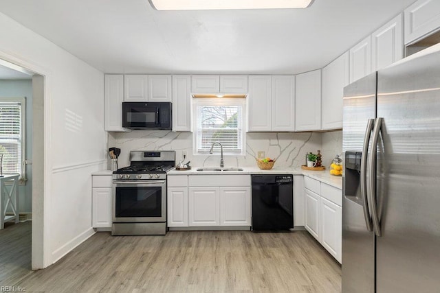 128 Wellons St, Suffolk, VA 23434 - kitchen featuring black appliances, a sink, light wood-style floors, light countertops, and plenty of natural light
