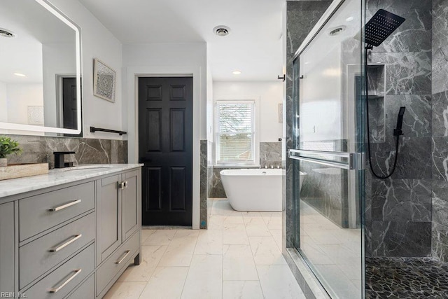 128 Wellons St, Suffolk, VA 23434 - bathroom with marble finish floors, a shower stall, vanity, a soaking tub, and tile walls
