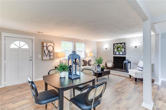5553 Rock Creek Ln, Virginia Beach, VA 23462 - dining area with light wood-style flooring, a brick fireplace, and baseboards