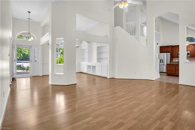 1300 Equinox Lndg, Chesapeake, VA 23322 - unfurnished living room with a high ceiling, baseboards, a ceiling fan, light wood-style flooring, and built in features