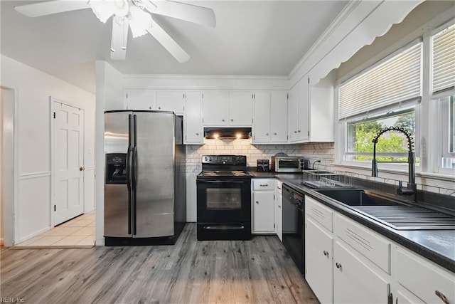 355 Nassau Pl, Hampton, VA 23666 - kitchen with black appliances, dark countertops, white cabinets, light wood-style floors, and decorative backsplash