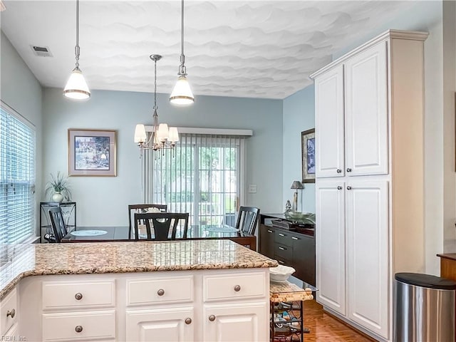 2884 Einstein Dr, Virginia Beach, VA 23456 - kitchen featuring a chandelier, a breakfast bar area, light stone countertops, and white cabinets