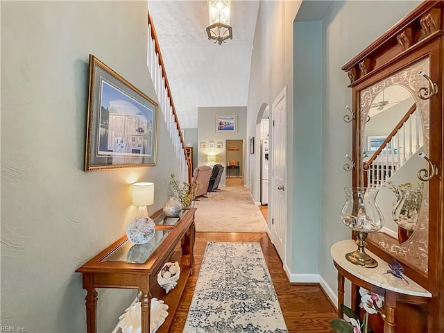 2884 Einstein Dr, Virginia Beach, VA 23456 - hall featuring stairs, arched walkways, baseboards, wood finished floors, and a high ceiling