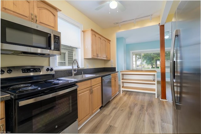 319 N First St, Hampton, VA 23664 - kitchen with appliances with stainless steel finishes, a sink, rail lighting, light wood finished floors, and dark countertops