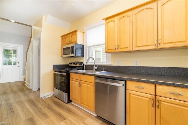 319 N First St, Hampton, VA 23664 - kitchen with stainless steel appliances, a sink, dark countertops, light wood finished floors, and light brown cabinets