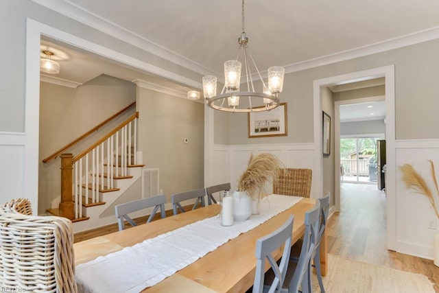 7412 Glenroie Ave, Norfolk, VA 23505 - dining space featuring a chandelier, crown molding, stairway, light wood-type flooring, and a decorative wall