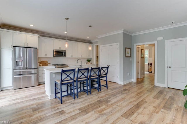 7412 Glenroie Ave, Norfolk, VA 23505 - kitchen featuring stainless steel appliances, crown molding, a breakfast bar area, white cabinets, and a kitchen island with sink