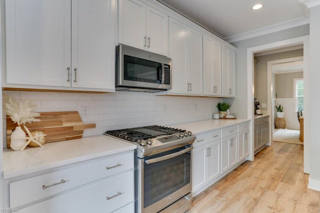 7412 Glenroie Ave, Norfolk, VA 23505 - kitchen with appliances with stainless steel finishes, white cabinets, light countertops, crown molding, and light wood finished floors