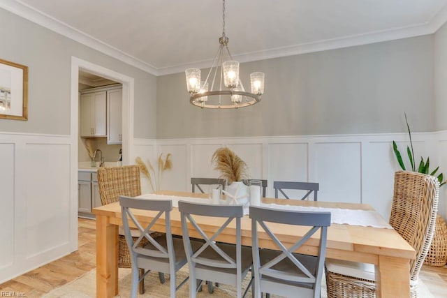 7412 Glenroie Ave, Norfolk, VA 23505 - dining space with a decorative wall, a chandelier, ornamental molding, wainscoting, and light wood-style floors