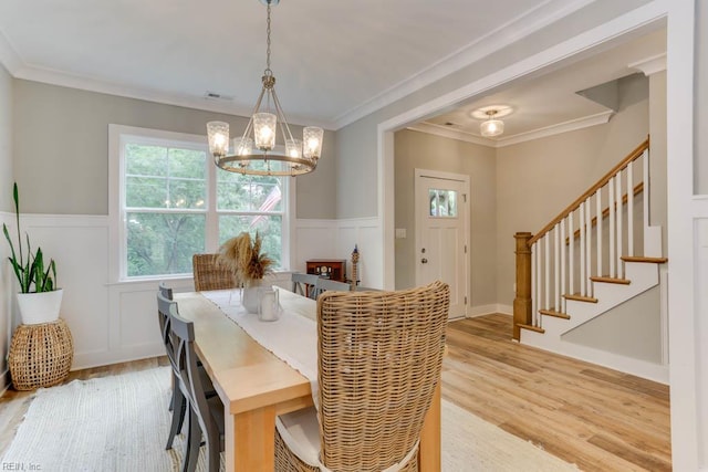 7412 Glenroie Ave, Norfolk, VA 23505 - dining area with a chandelier, stairway, light wood-style floors, a wainscoted wall, and a decorative wall