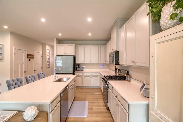 1621 Redwing Arch, Chesapeake, VA 23323 - kitchen featuring appliances with stainless steel finishes, a sink, light countertops, light wood finished floors, and recessed lighting