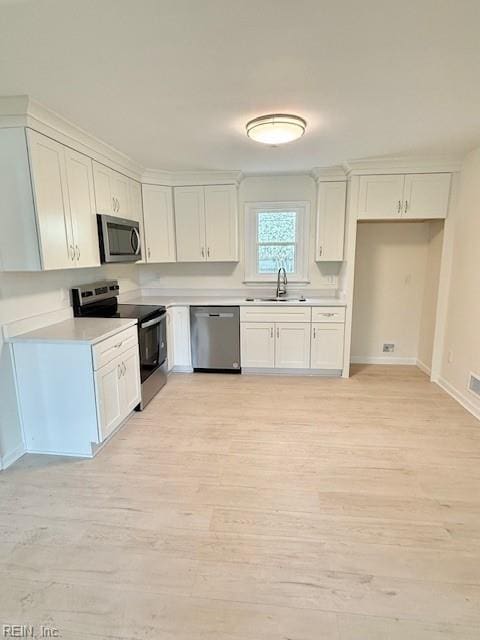291 Fair Meadows Rd, Virginia Beach, VA 23462 - kitchen featuring stainless steel appliances, white cabinetry, light countertops, light wood-style floors, and a sink
