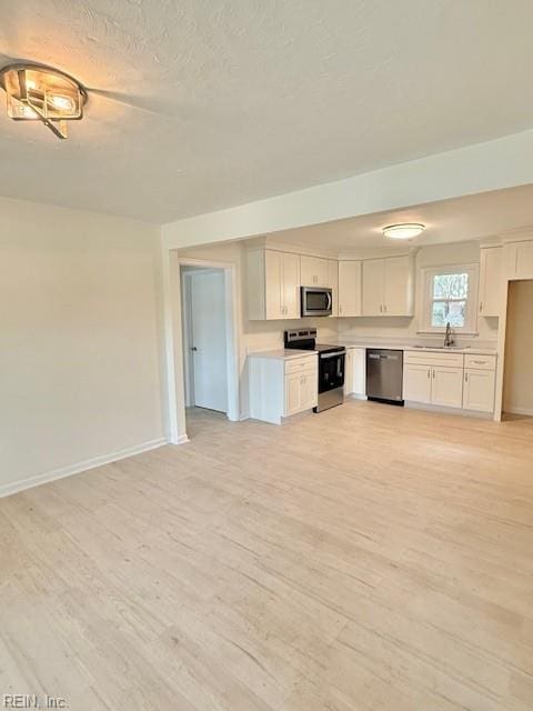 291 Fair Meadows Rd, Virginia Beach, VA 23462 - kitchen featuring stainless steel appliances, white cabinets, light countertops, light wood-style flooring, and a textured ceiling