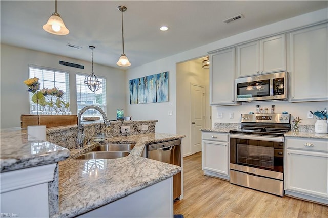 3729 Longhill Arch, Chesapeake, VA 23323 - kitchen with stainless steel appliances, a sink, light wood-style floors, decorative light fixtures, and light stone counters