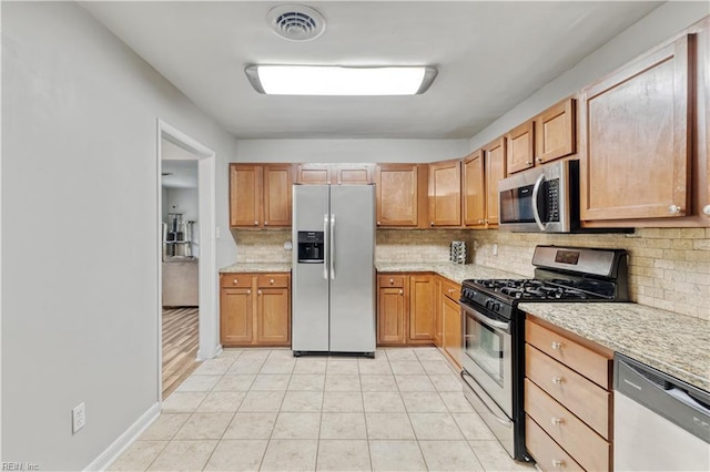 2720 Juniper St, Norfolk, VA 23513 - kitchen with appliances with stainless steel finishes, backsplash, and light tile patterned floors