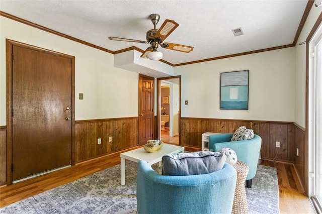 214 Silver Isles Blvd, Hampton, VA 23664 - sitting room featuring wainscoting, wood finished floors, wooden walls, a ceiling fan, and crown molding