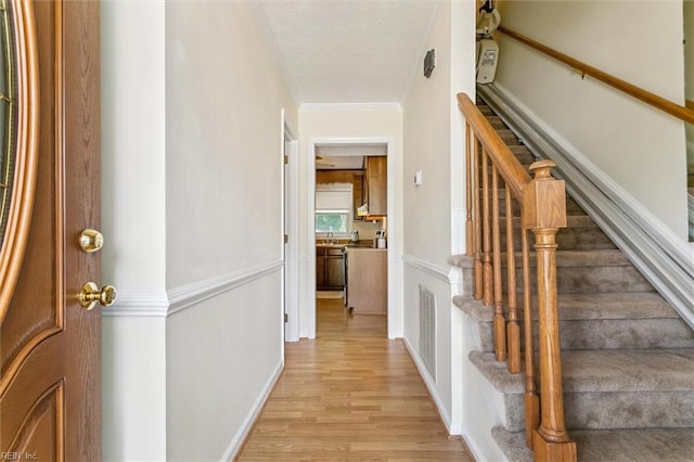 214 Silver Isles Blvd, Hampton, VA 23664 - foyer with light wood-style flooring, stairs, a textured ceiling, baseboards, and crown molding