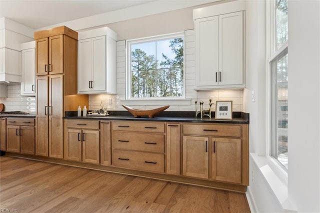 1912 Mccoy Rd, Chesapeake, VA 23323 - kitchen with light wood finished floors, dark countertops, backsplash, and brown cabinets