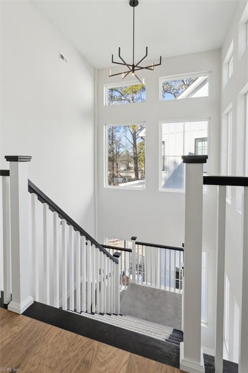 1912 Mccoy Rd, Chesapeake, VA 23323 - stairway featuring wood finished floors, a chandelier, healthy amount of natural light, a high ceiling, and baseboards