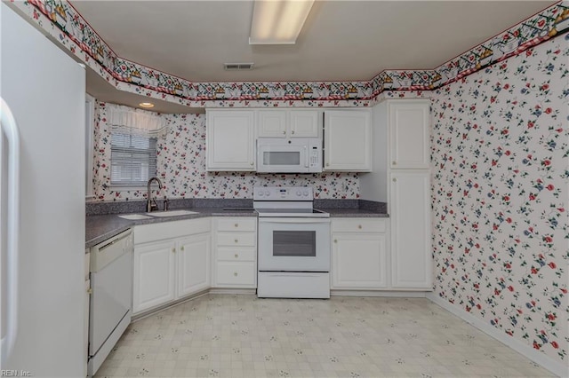 238 Wingate Dr, Williamsburg, VA 23185 - kitchen with white appliances, wallpapered walls, dark countertops, light flooring, and white cabinetry