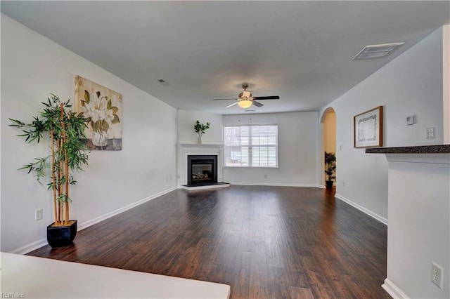 5233 Winery Dr, Chesapeake, VA 23321 - unfurnished living room featuring dark wood-type flooring, arched walkways, a ceiling fan, a glass covered fireplace, and baseboards