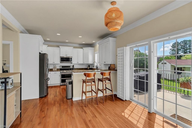 921 Justin Lee Way, Chesapeake, VA 23322 - kitchen featuring stainless steel appliances, a peninsula, crown molding, white cabinets, and light wood-style flooring