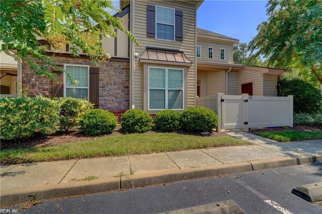 401 Blue Heron Trl, Carrollton, VA 23314 - view of front of house with a gate, stone siding, and a standing seam roof
